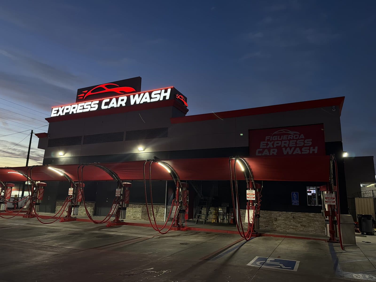 Illuminated Figueroa Express Car Wash sign at dusk with red wash curtains inside the tunnel